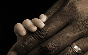 close up photography of baby's hand holding adult hand